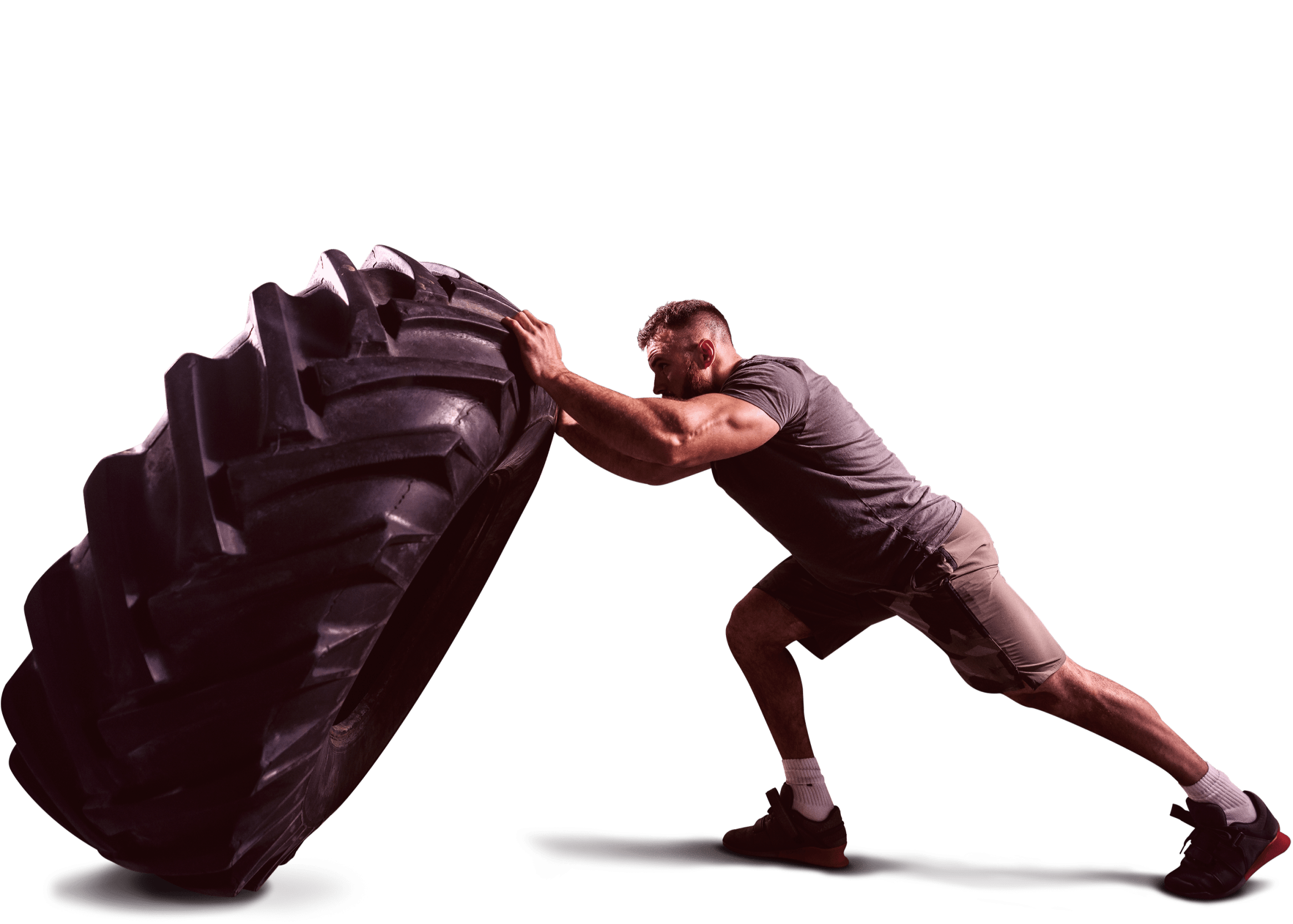 Well built man pushing a tyre