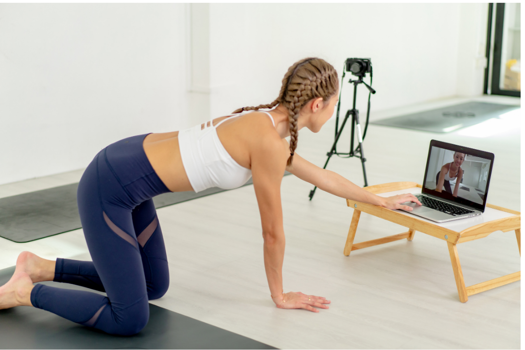 Women with proper live-streaming set-up and digital camera about to start a yoga classs
