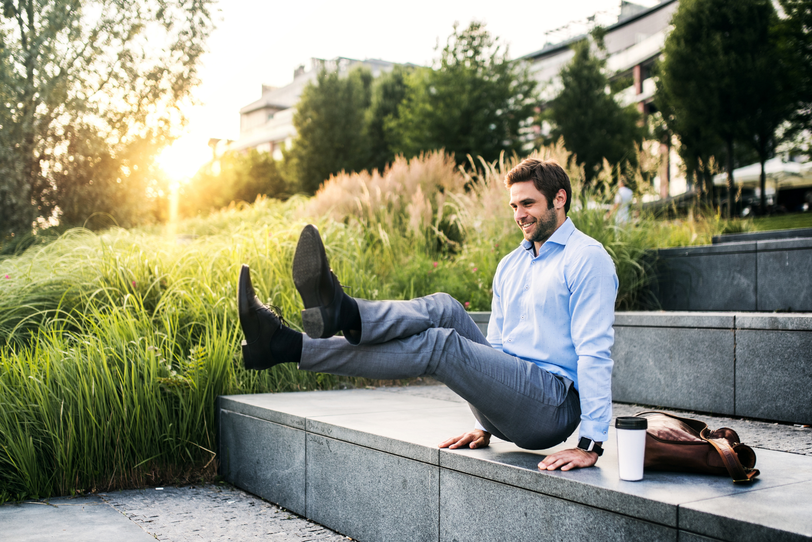 Man in office attire performing a fitness posture on stairs