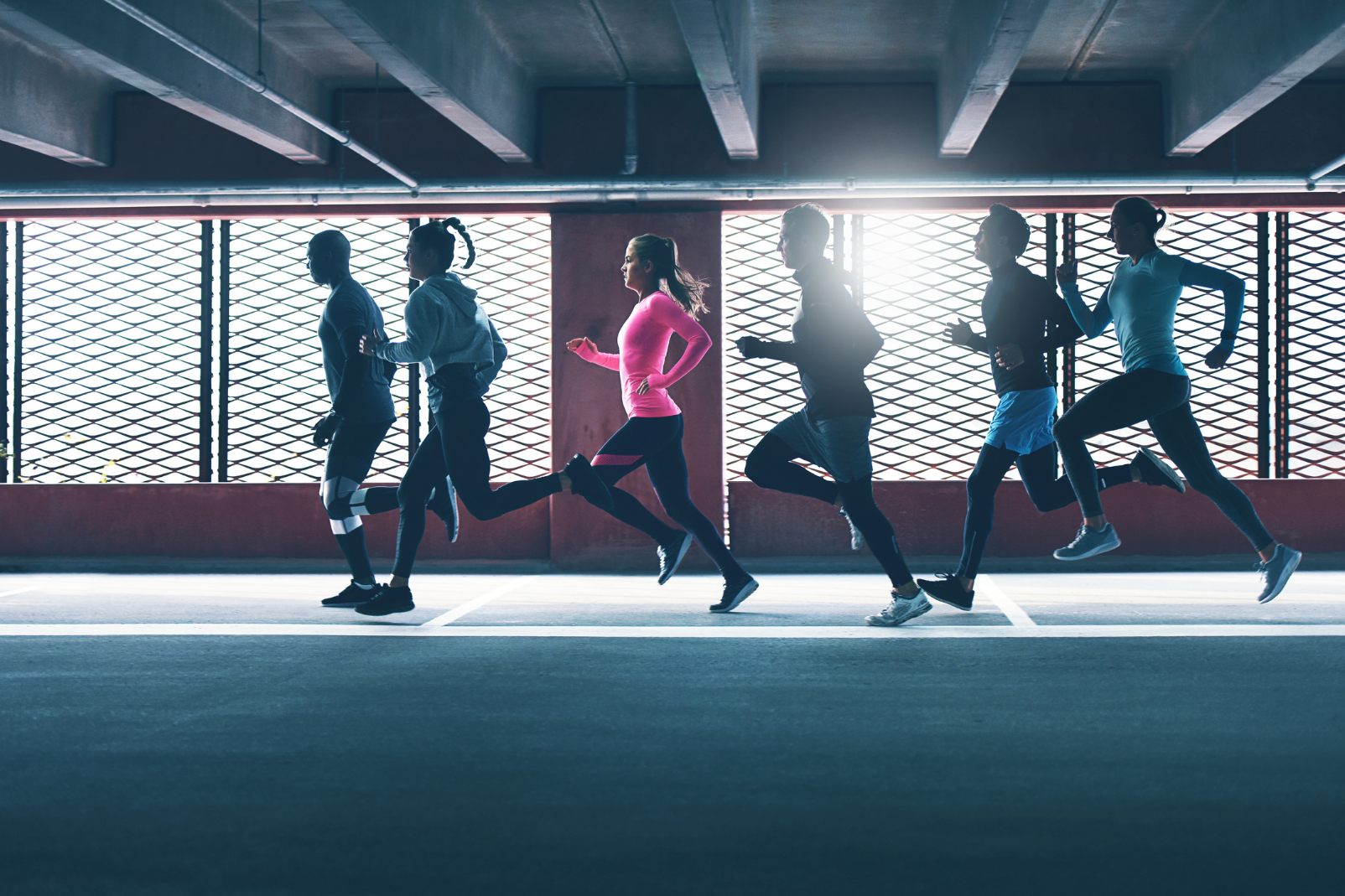 A group of runners running in a dim lit underground basement