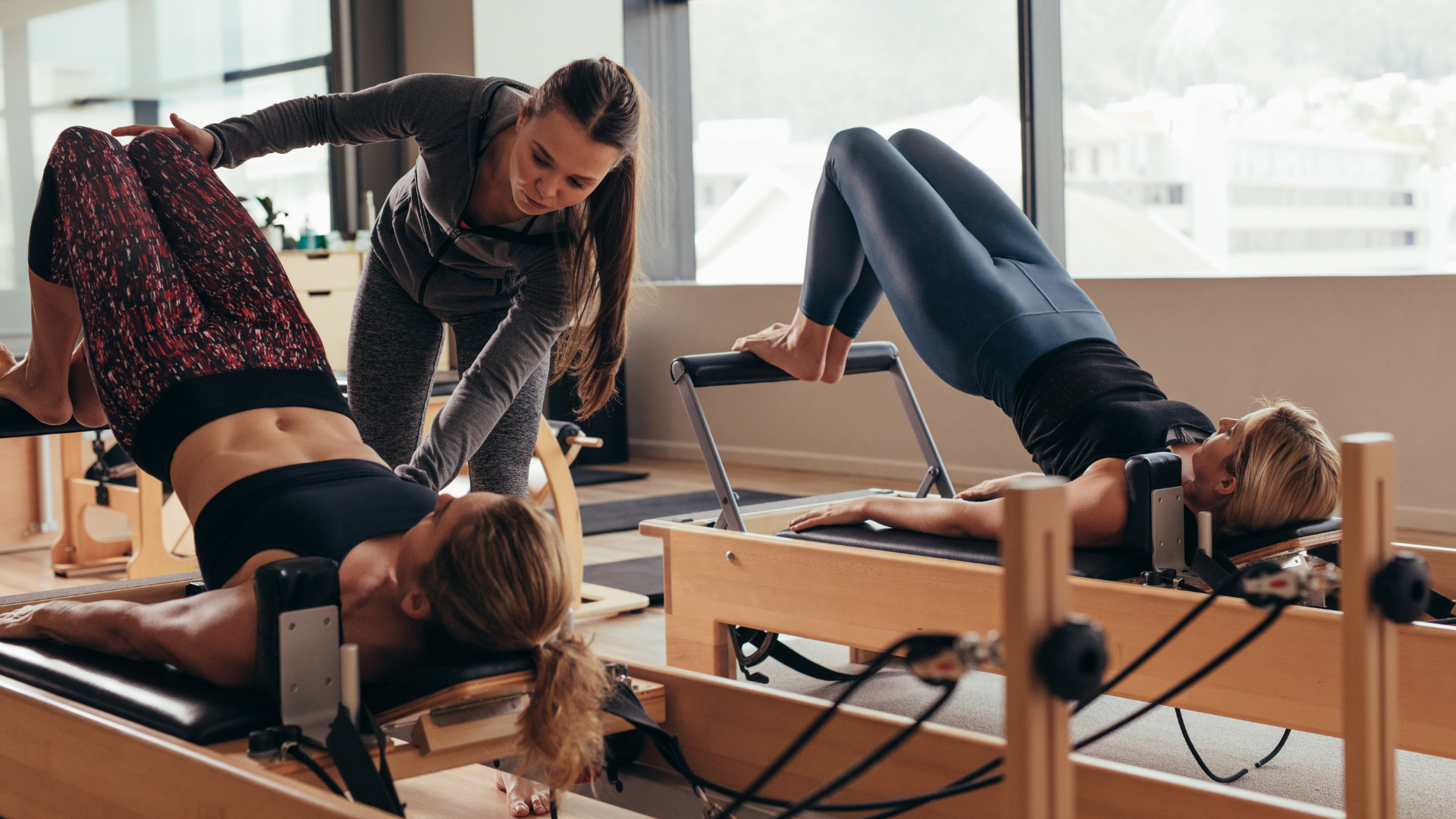 A fitness trainer guiding her students to use a complex fitness equipment targeting leg workout