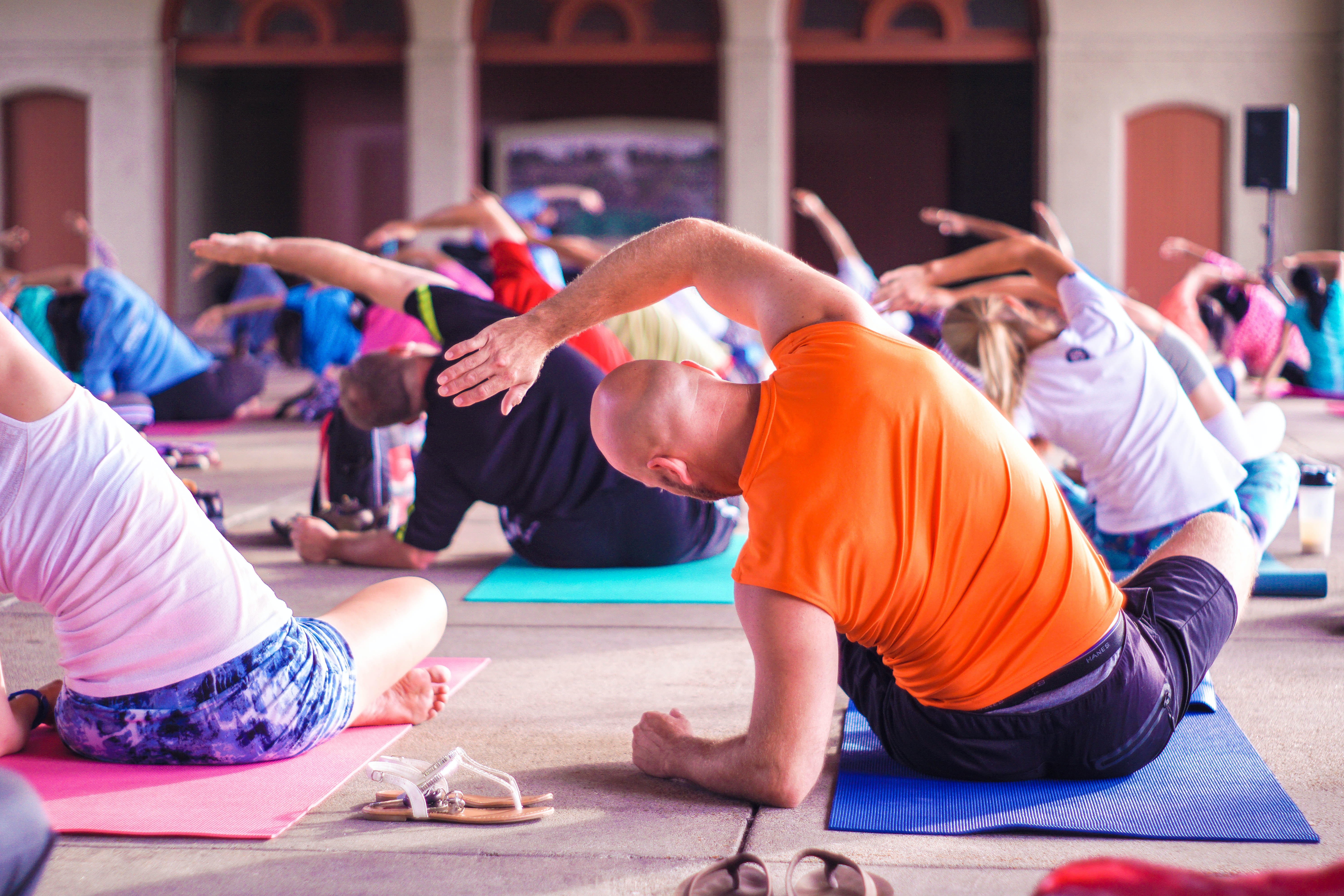 A group of yogis bending left while attending a yoga class.