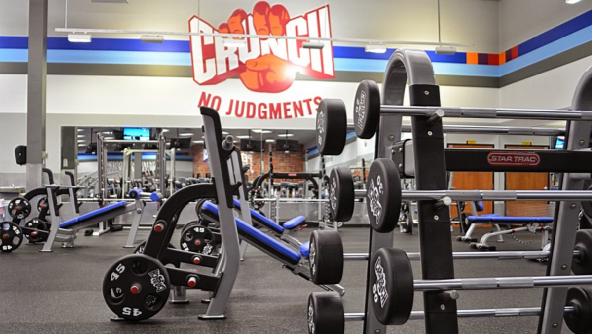 Crunch fitness gym with different equipments and "No Judgements" written on its wall.