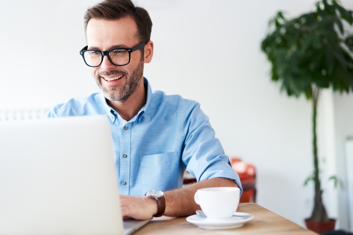 drop surfing: smiling man looking at his laptop
