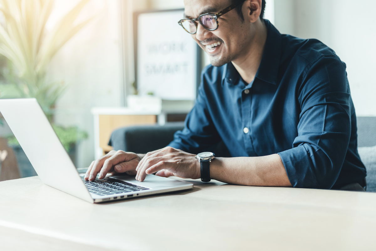 product tour: Smiling man using his laptop