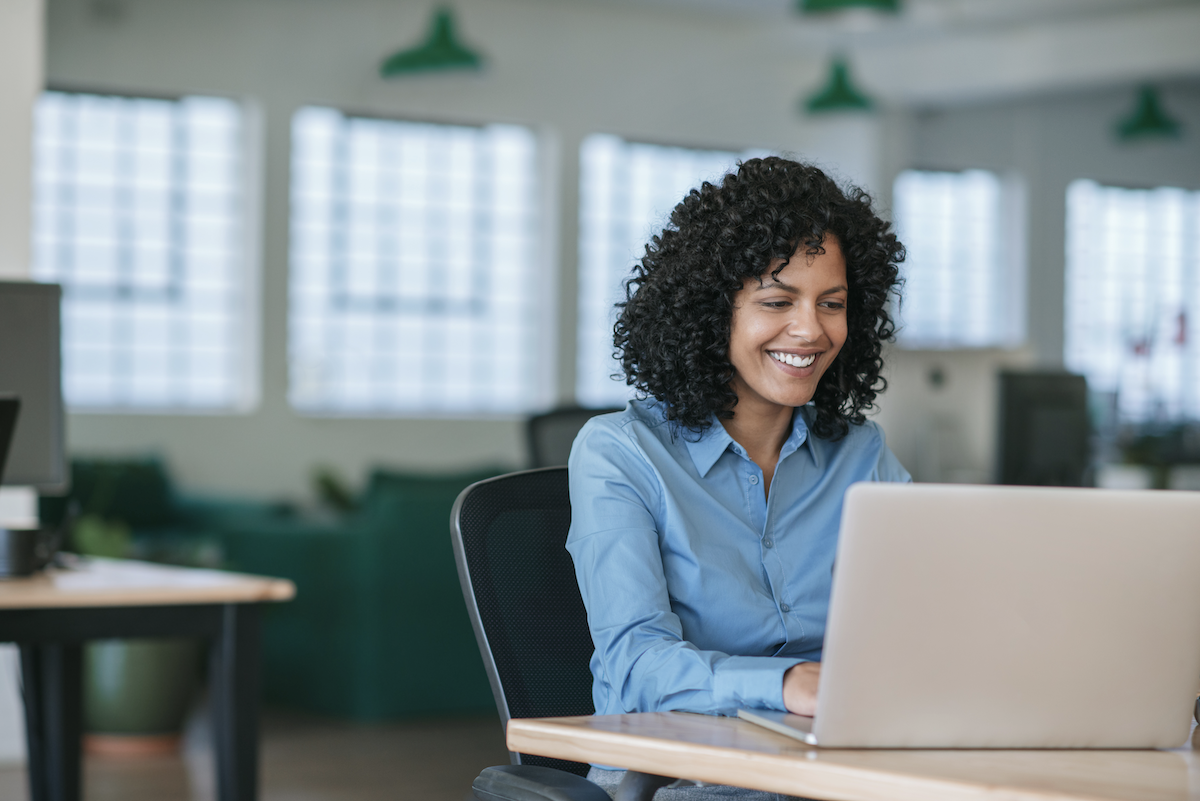 customer engagement software: Smiling woman using her laptop