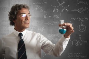 Academic Scientist Marvels At Blue Chemical Reaction Near Chalkboard