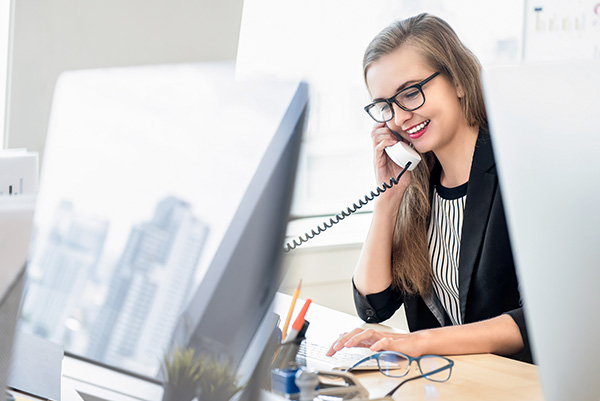 Dentist's receptionist answering a call on her VoIP phone