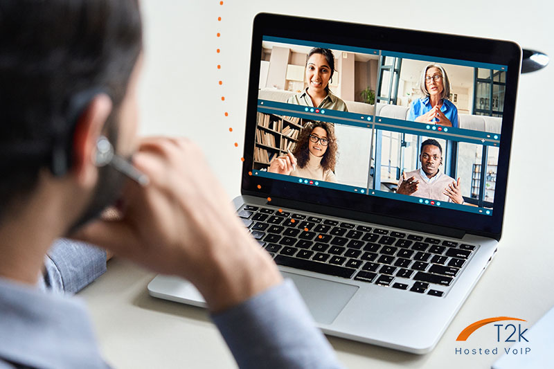 Man using VoIP on computer softphone and talking to others via video