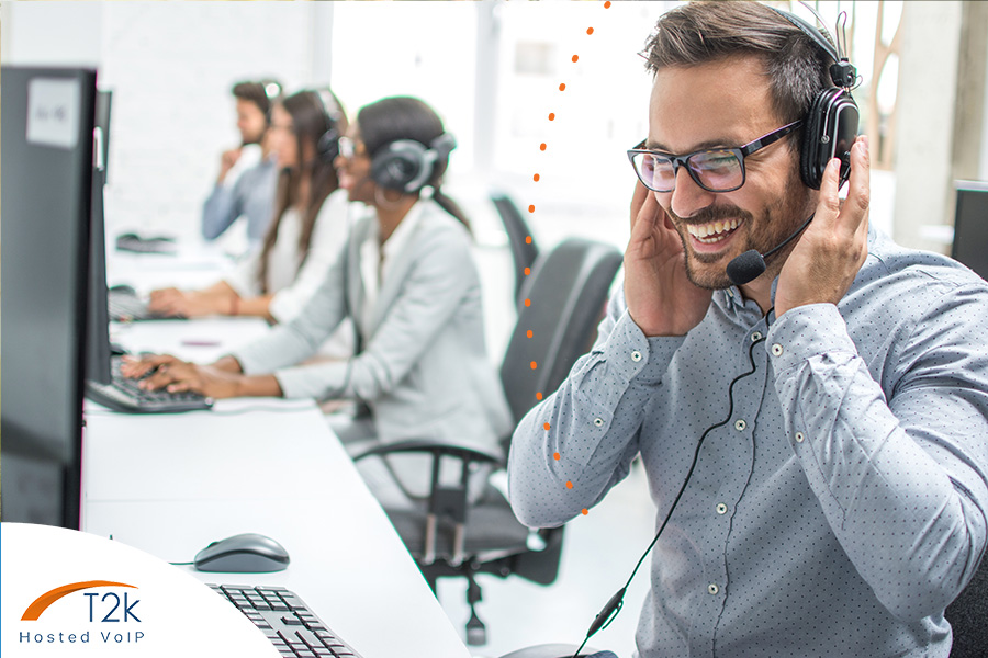 Man in a call centre using VoIP phone system to make outbound phone call