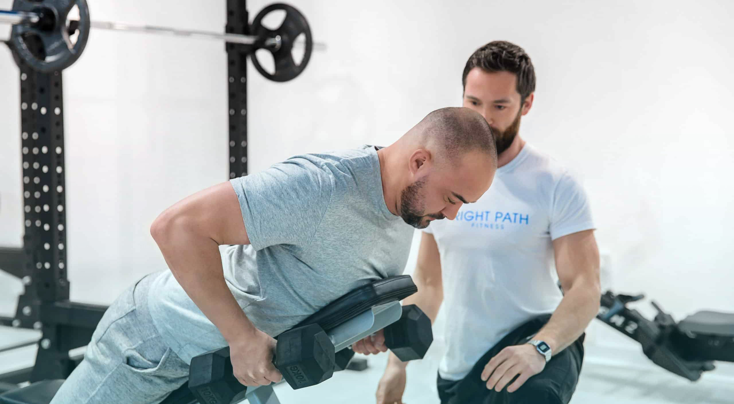 Hyperextension with personal trainer in gym