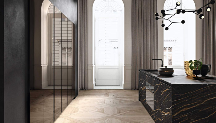 Cucina scura con penisola centrale scura con frontali neri effetto marmo e colonne con frontali in vetro fumè