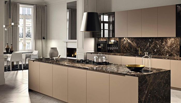 Cucina lineare con isola centrale con fianchi e top effetto marmo e pensili sospesi con ante in vetro