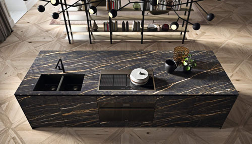 Cucina moderna scura con isola centrale con ante ad apertura con gola nera e top e frontali in gres