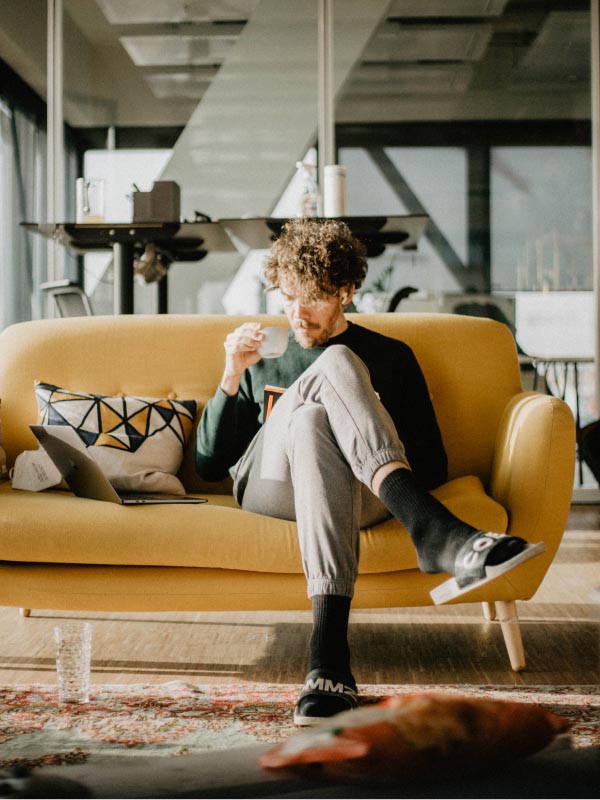 Person sitting on a sofa while working.