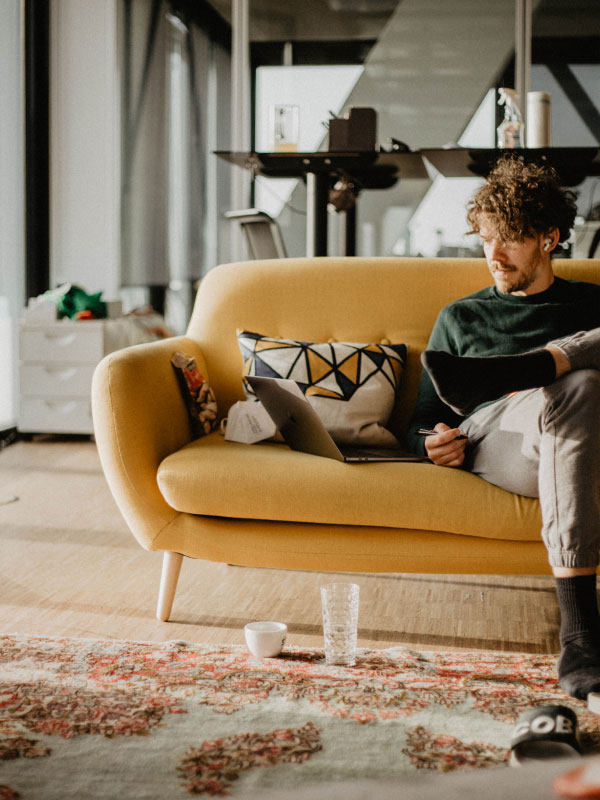 Person sitting on a sofa while working.