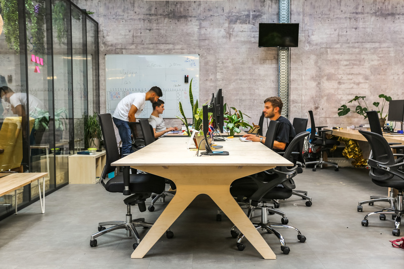 Plusieurs personnes sont assises devant un bureau bench dans un espace collaboratif