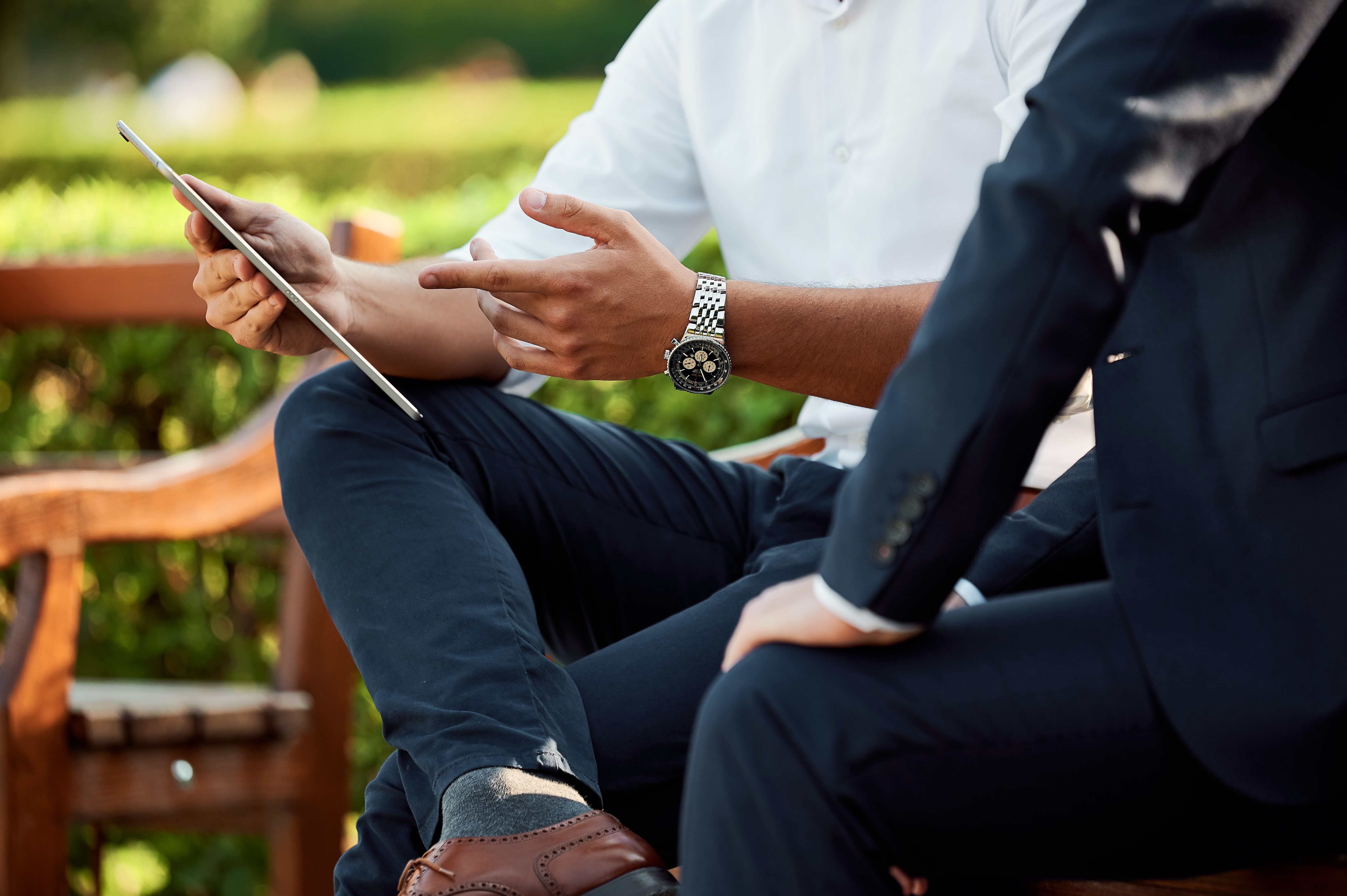 Hands showing information on a tablet to someone