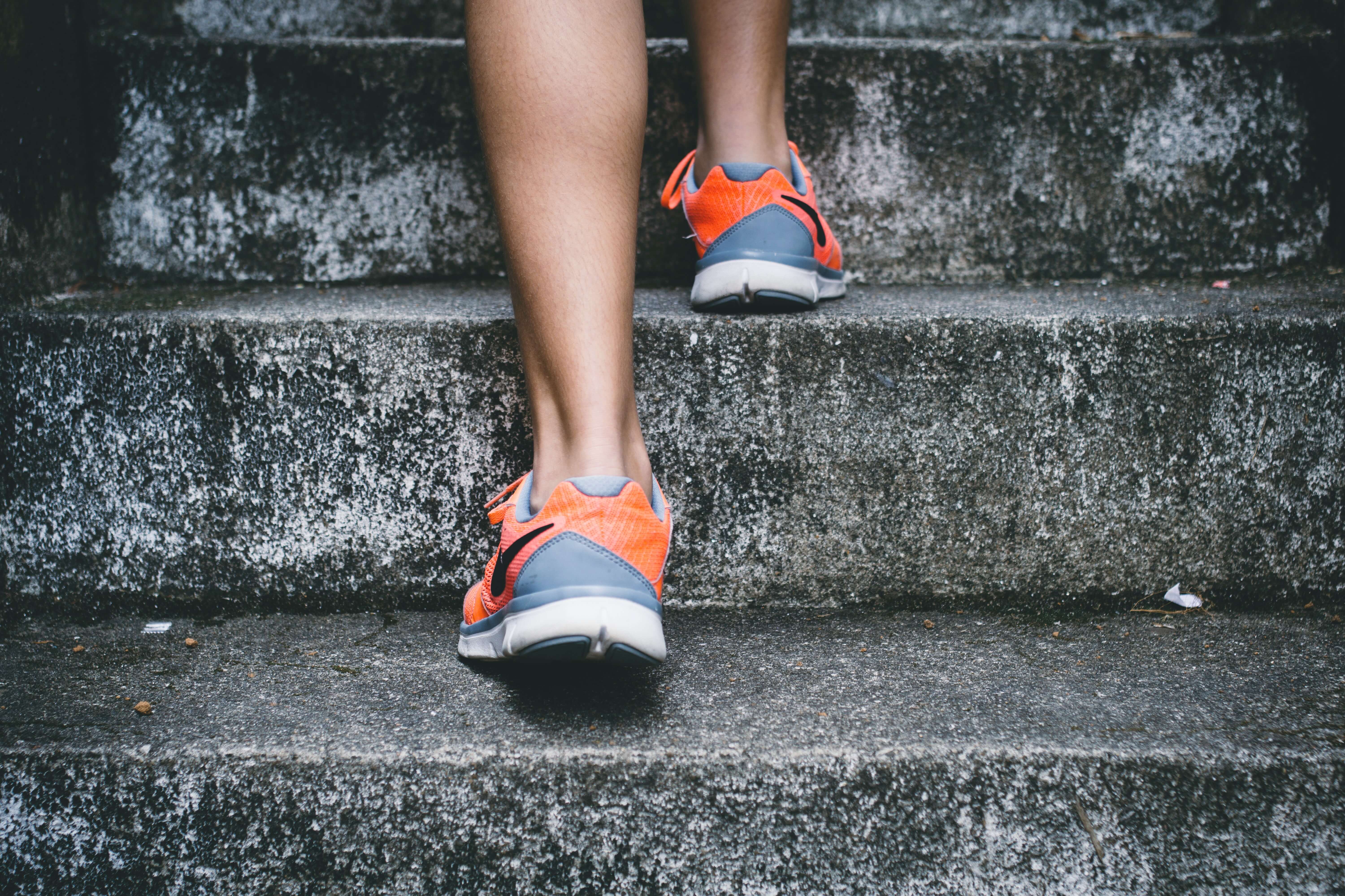 Montée d'escalier avec focus sur les baskets du sportif