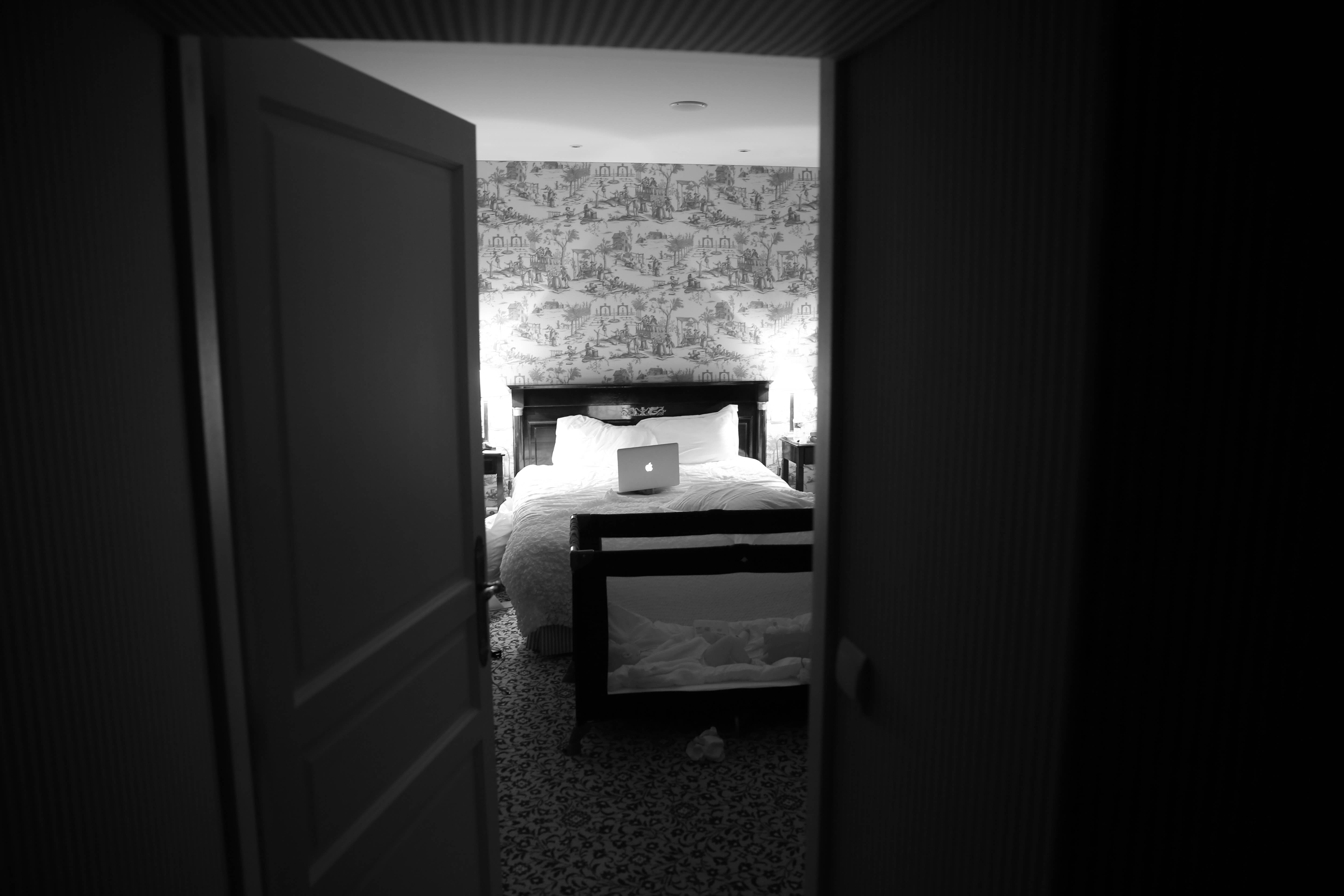 Photographie d'une chambre à coucher, un ordinteur portable est posé sur lit