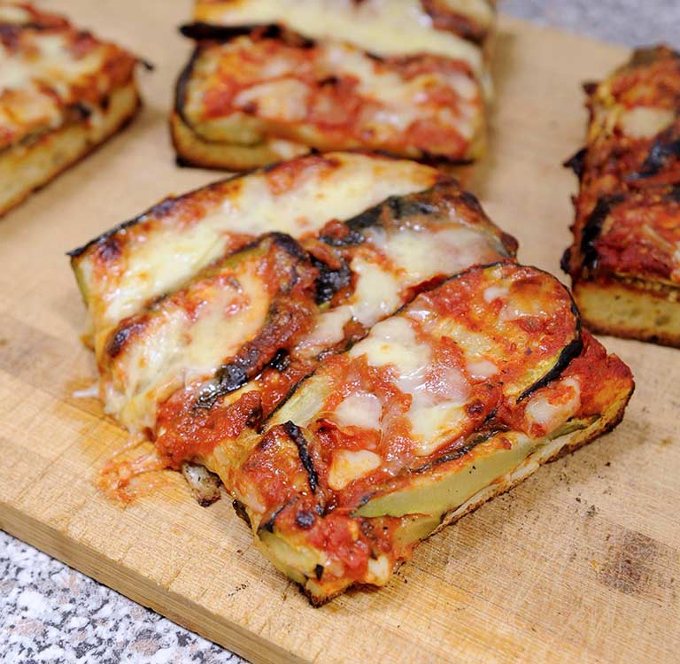 Focaccia Parmigiana von Bäckerei Fenuta (geschnitten à 10x15cm)Mit: Zucchini, Auberginen und Mozzarella