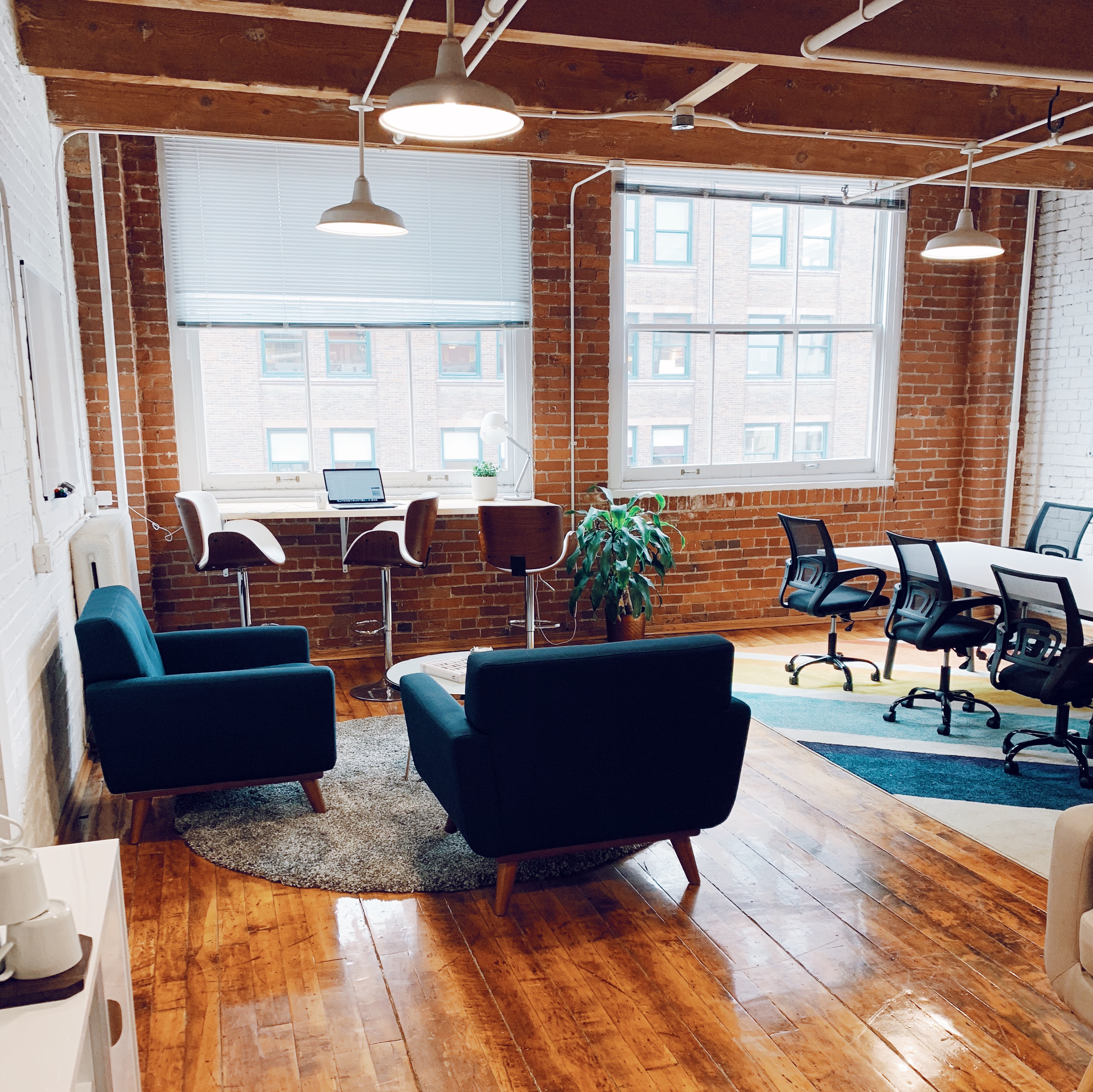 Beautiful mid-century office space with blue chairs and hardwood floors