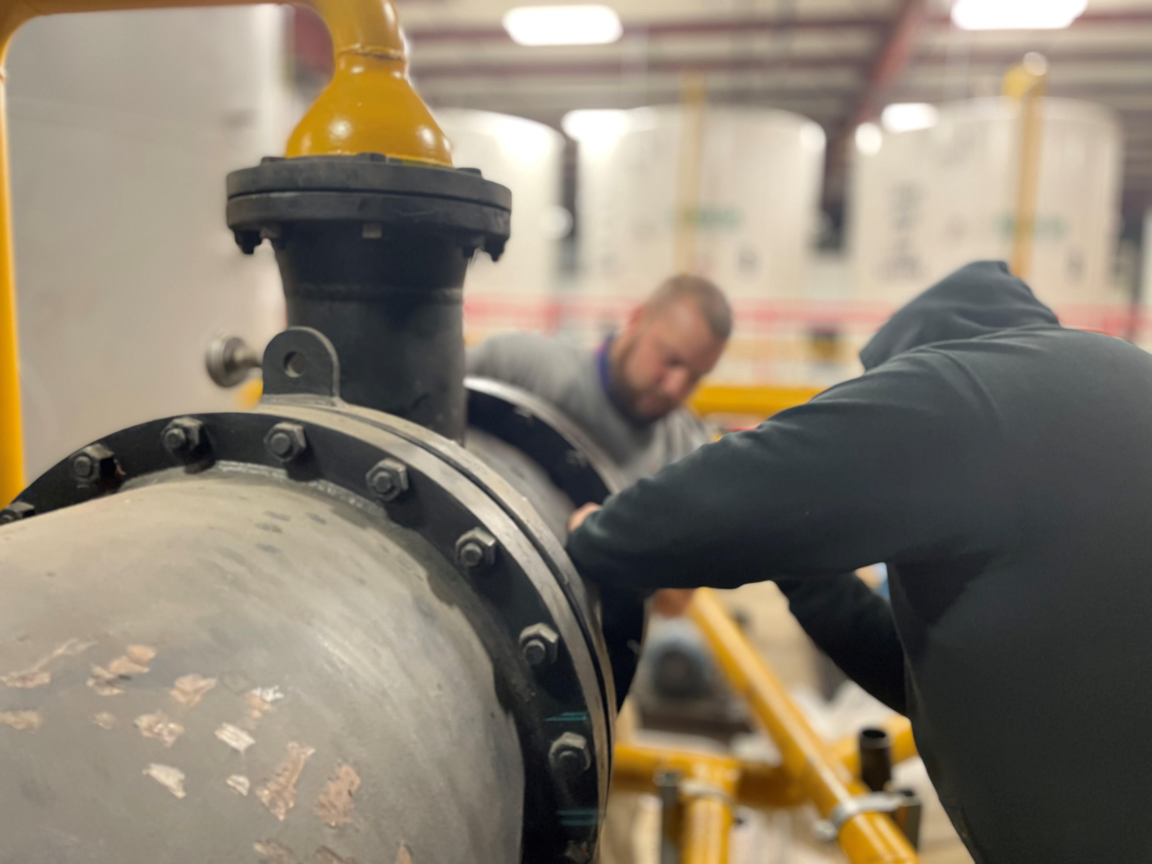two men working on a HVAC unit