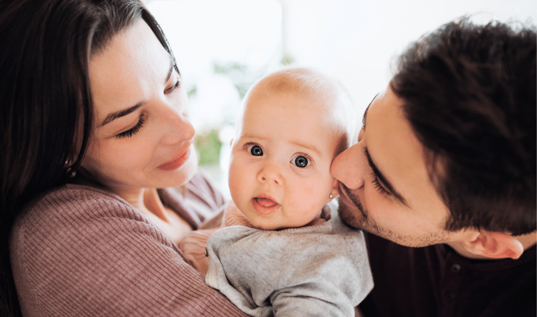 Young Couple with a Baby Indoors at Home.