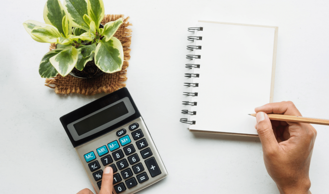 hand holding pancil writing on blank notebook and touch calculator life insurance.