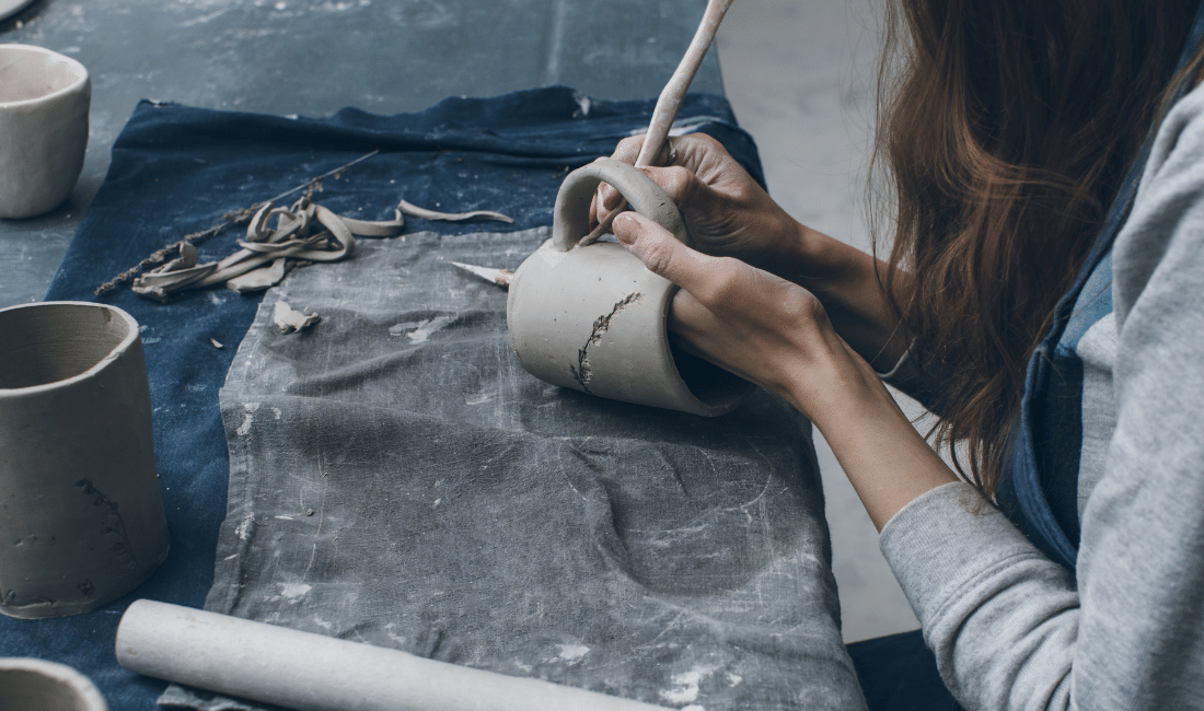 Young business owner working with clay mug