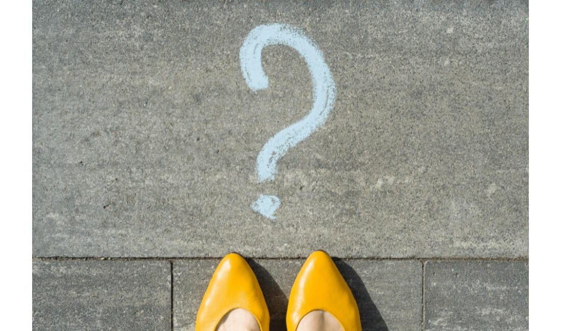 Woman standing behind question mark,
