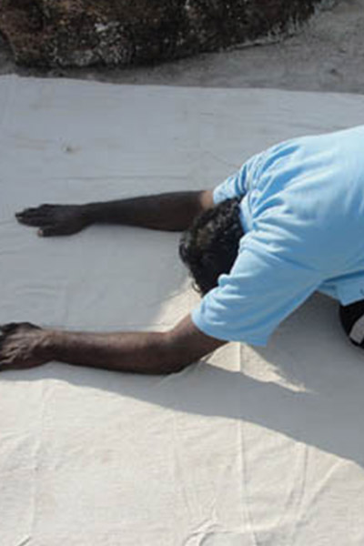 man with his hands on the ground as he bends forward in a yoga stretch