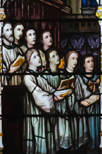 stained glass picture of saints praying