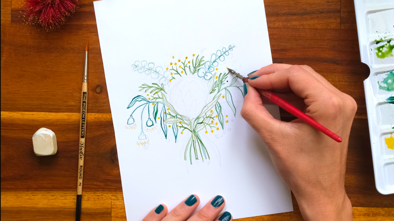 Artists's hands drawing wattle blosssoms with a nib