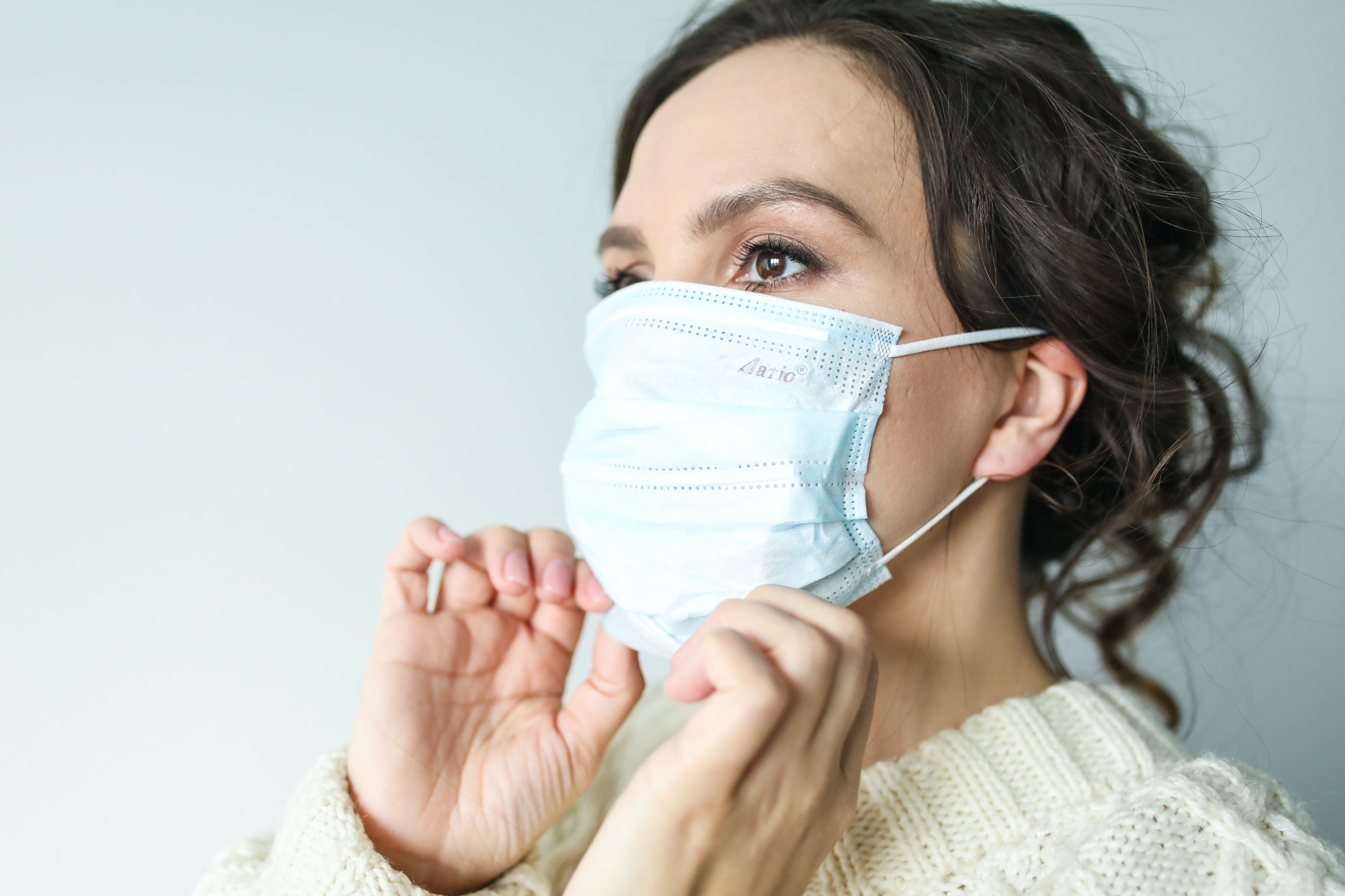 woman putting a Covid face mask