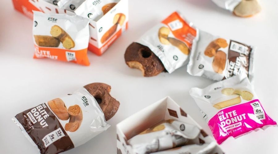 Packages of individually wrapped and partially open Eliet Sweets protein donuts.