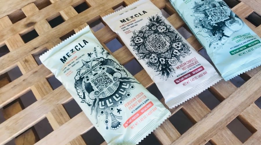 Three Mezcla protein bars next to each other on a table.