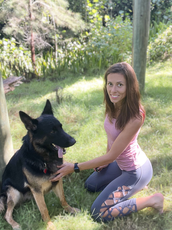 Sophie sitting outside next to her German Shepherd wearing the Healbe GoBe 3 fitness tracker.