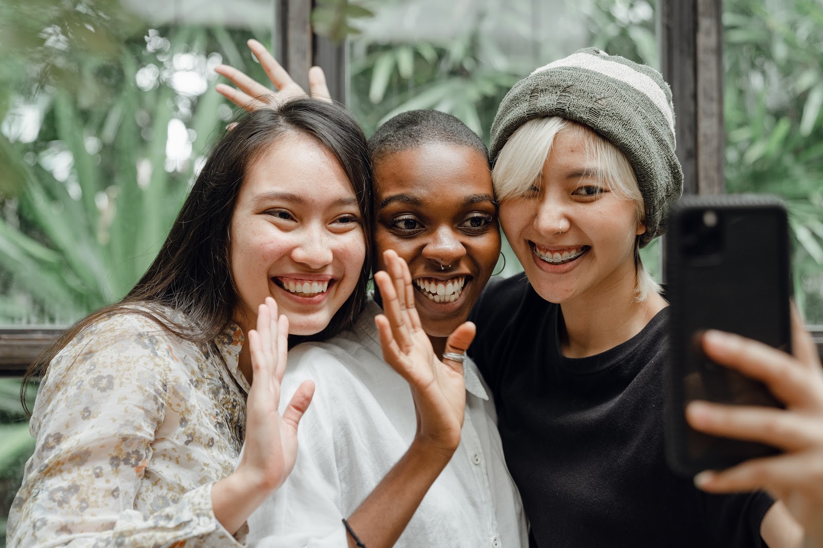 three friends smiling in front of a phone