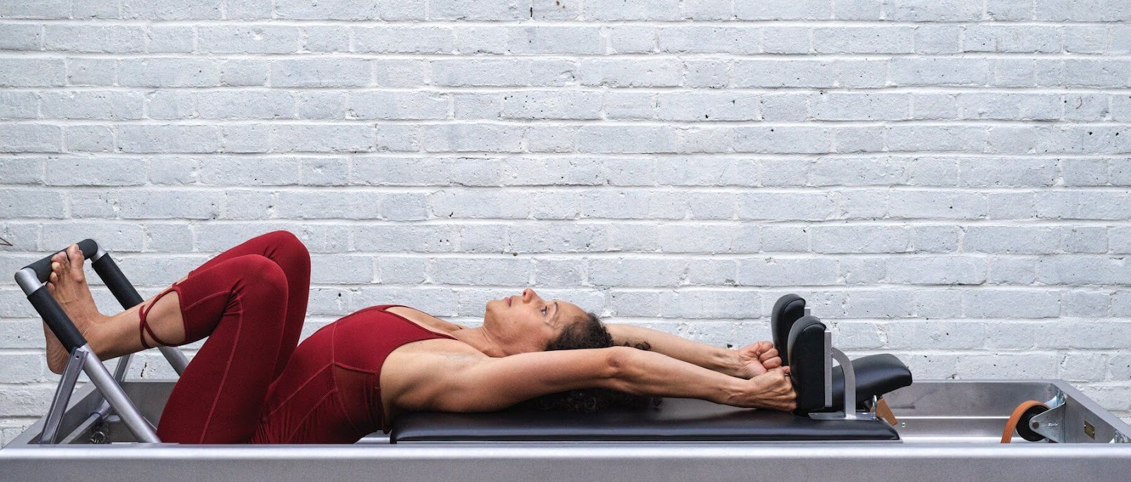 woman using archive reformer apparatus