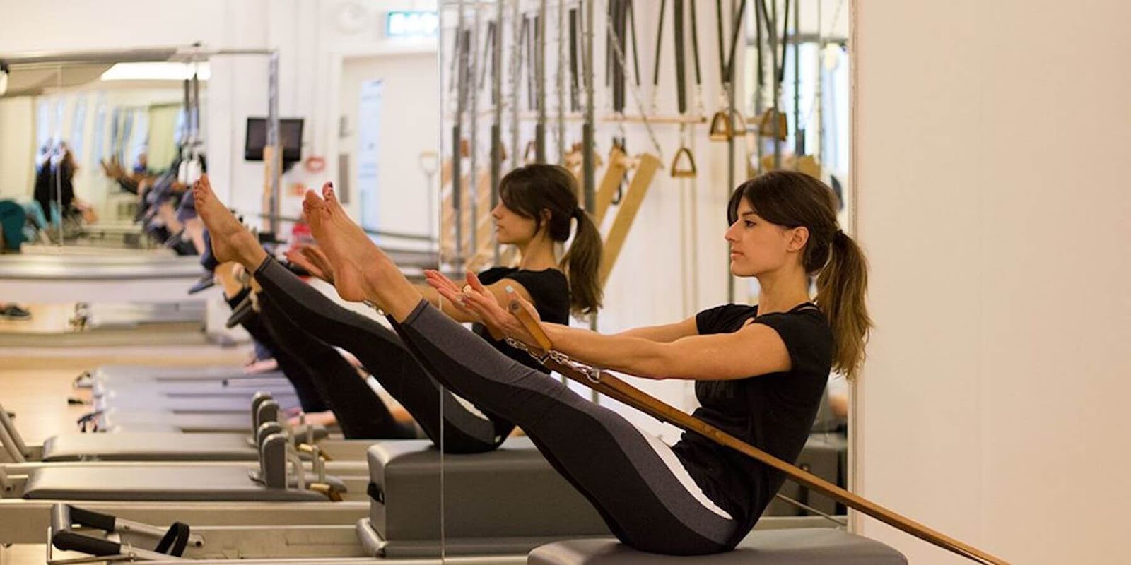 woman practicing Pilates on a machine