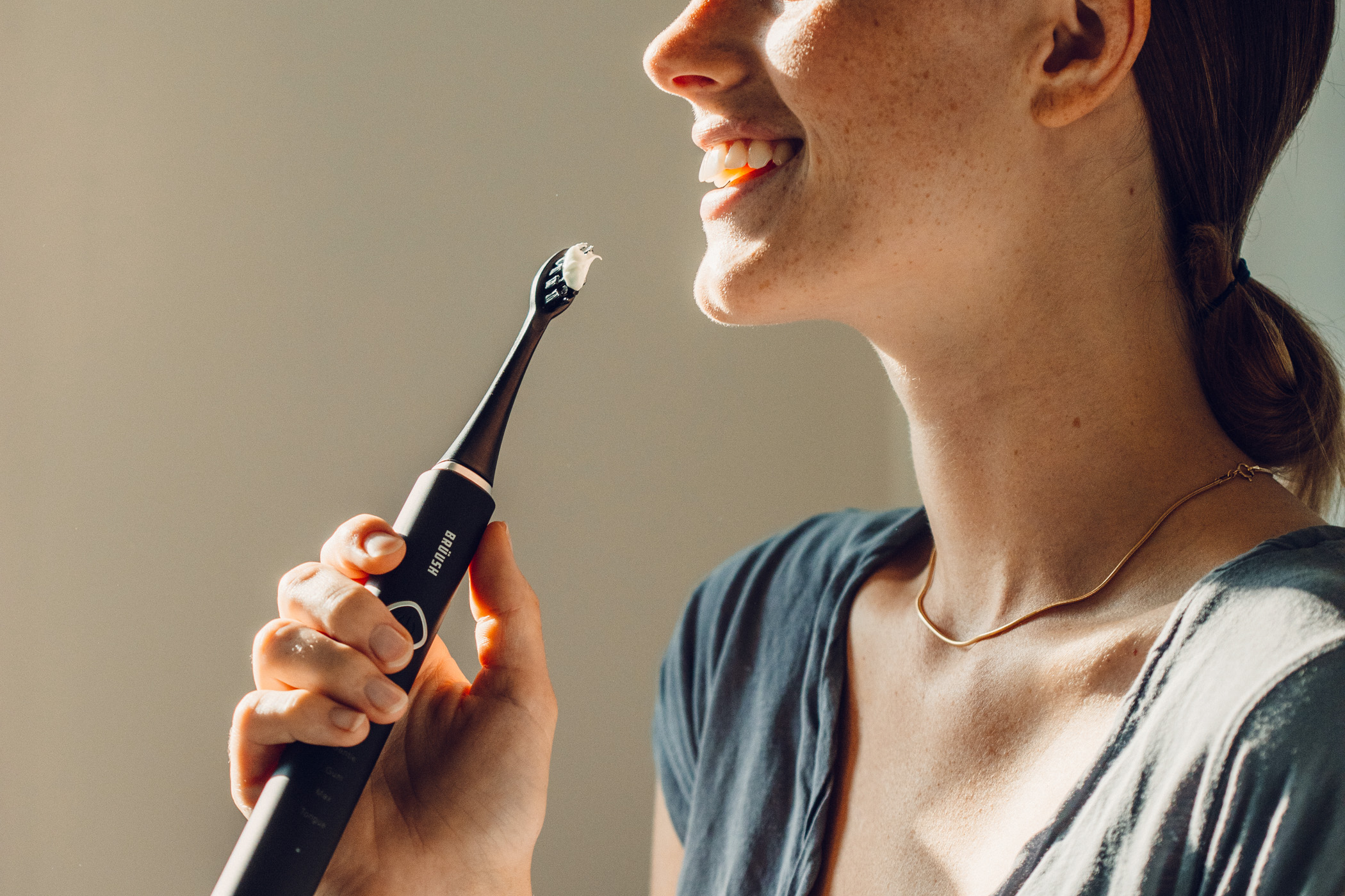 woman using best electric toothbrush