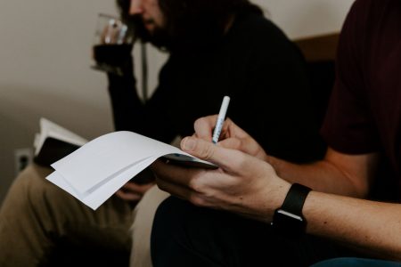 person writing on a memo notepad