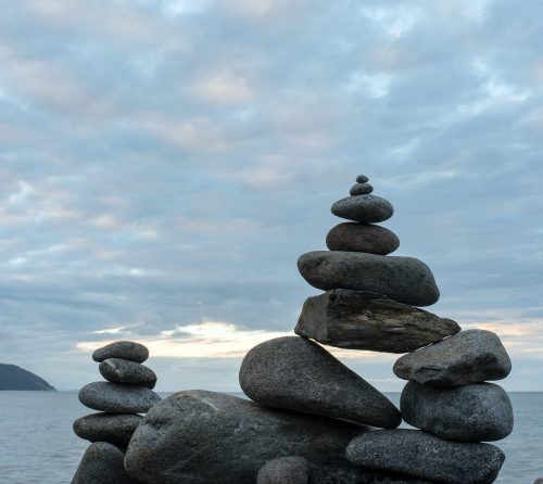 stacked stones in front of a lake
