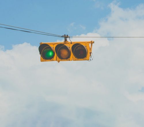 green traffic light hanging in the sky