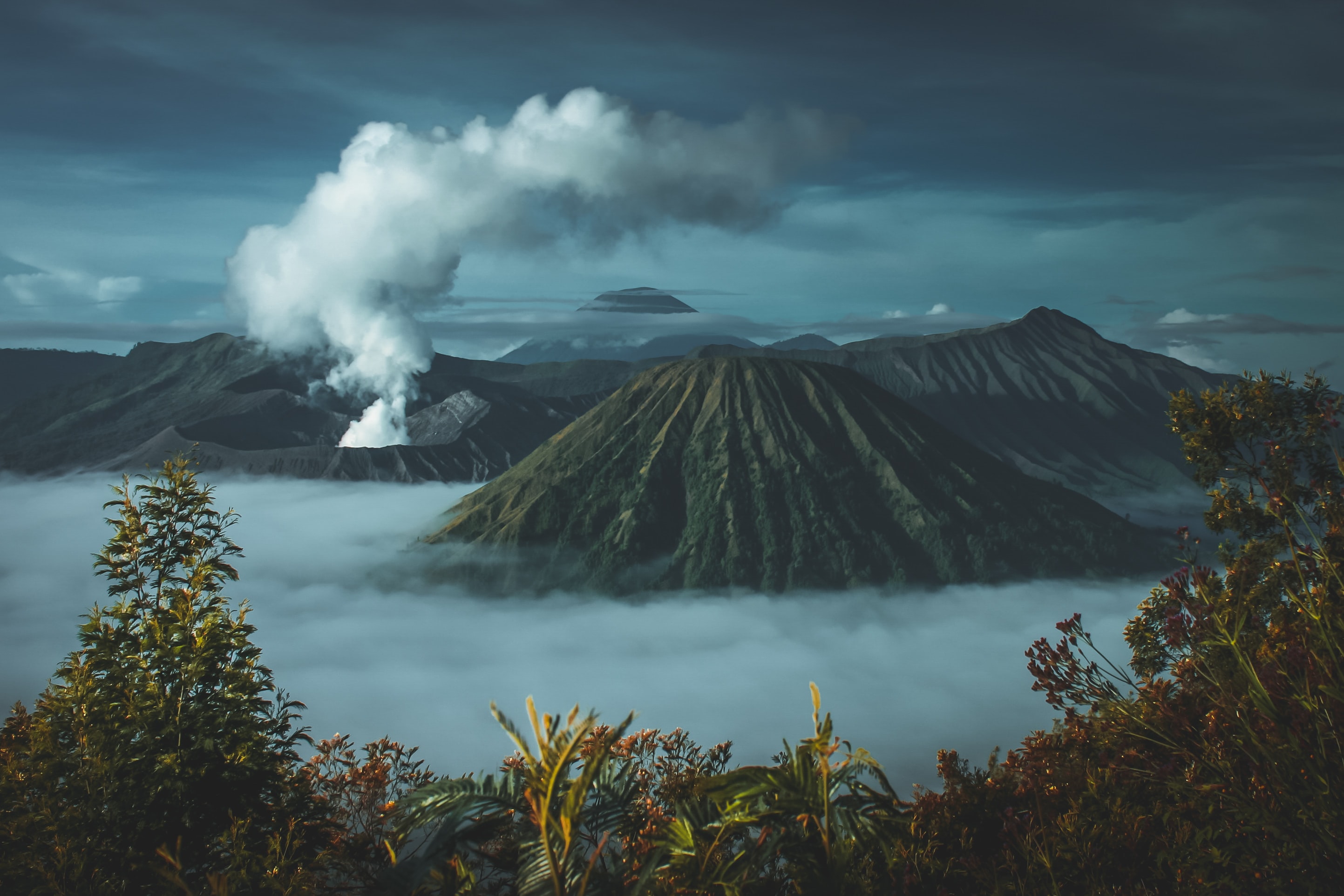 a volcano smoking in a tropical setting
