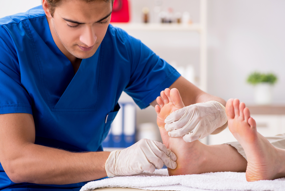 concimed podiatrist attends to diabetic patient's foot and teaching proper foot care