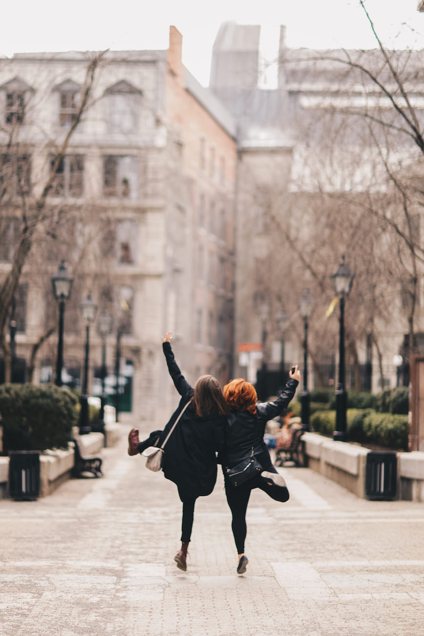 Two people joyfully walking down a city street