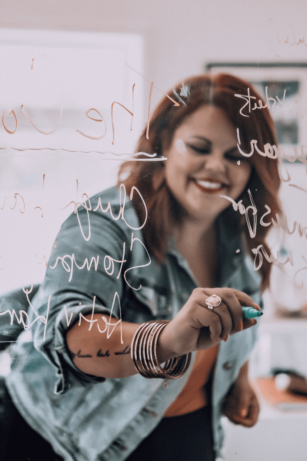 Photo of Karine Parthenais writing on a glass wall with marker