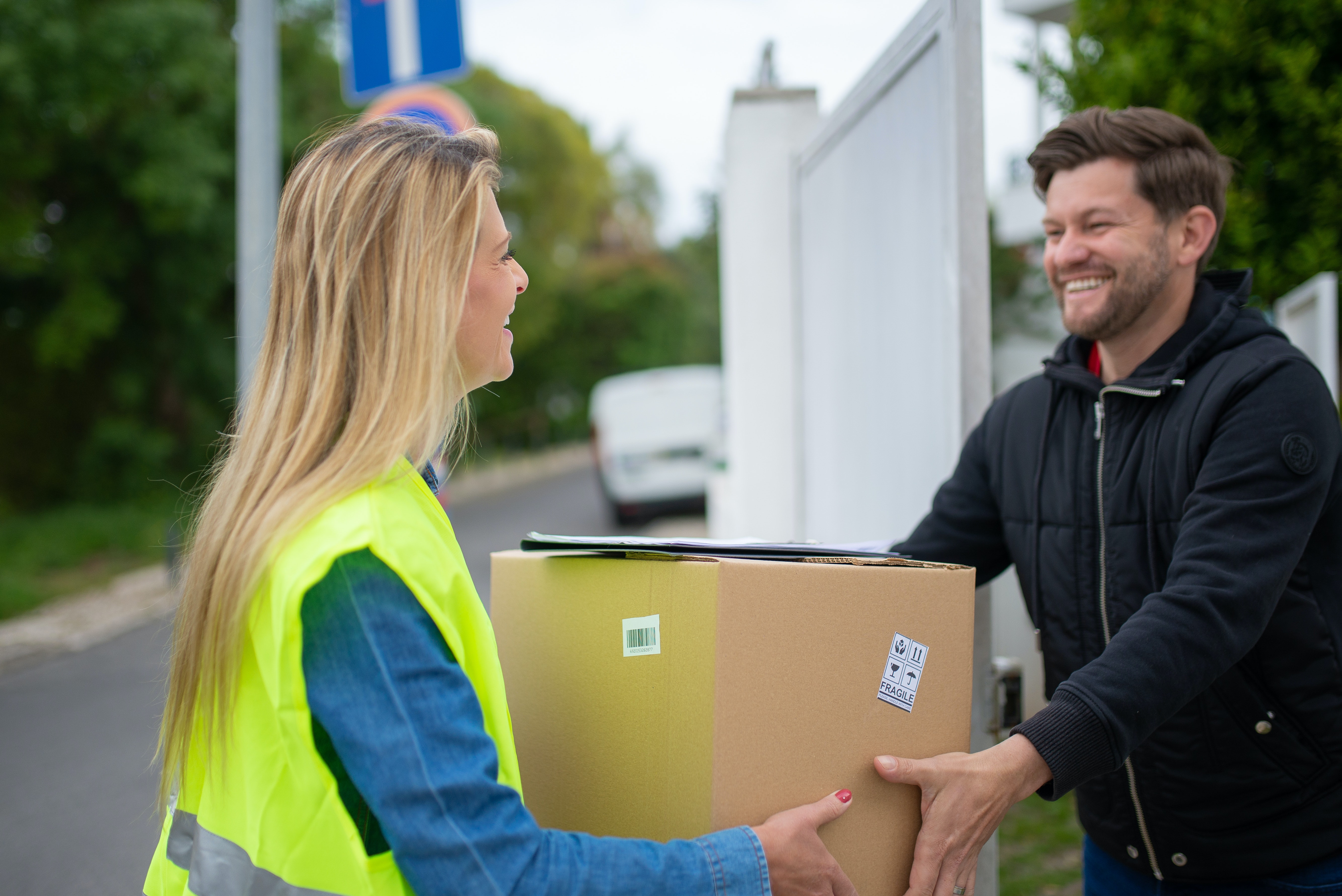 a man receiving a parcel from delivery woman